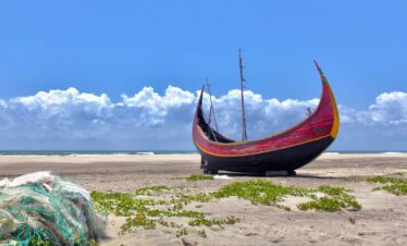 brown boat on white sand during daytime