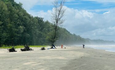 a group of people standing on top of a sandy beach