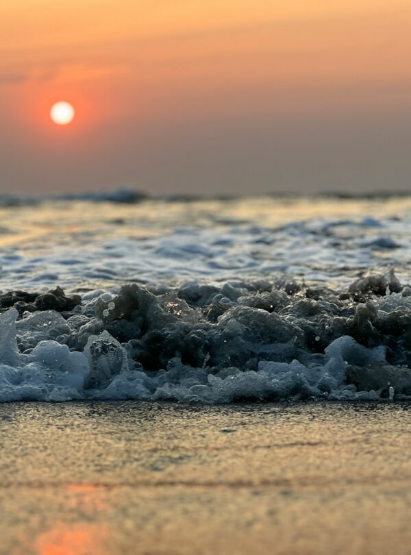 the sun is setting over the ocean waves