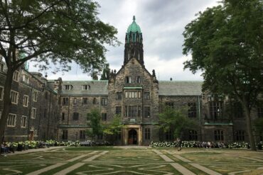 brown and gray concrete building near green trees under blue sky during daytime