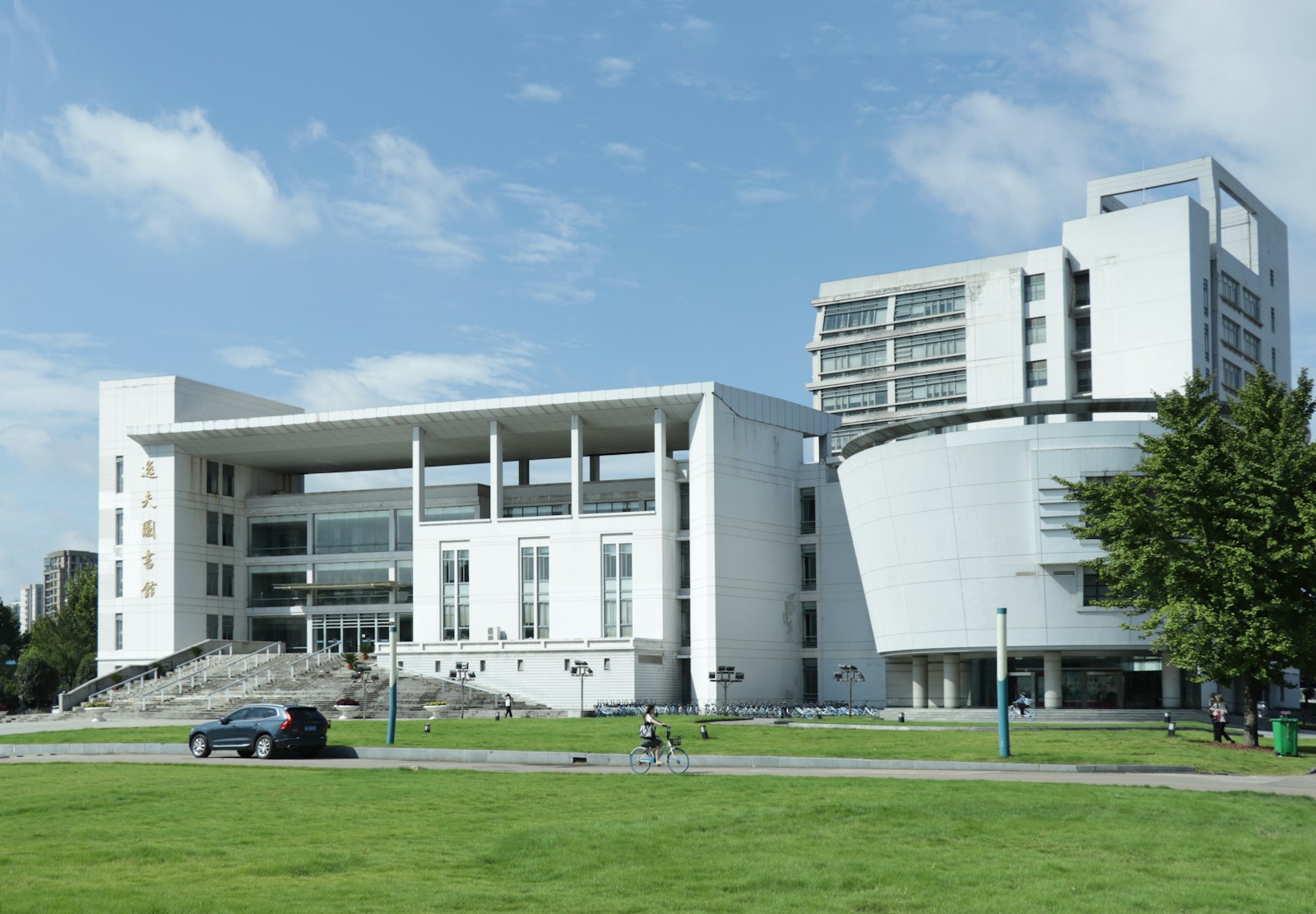 a large white building sitting on top of a lush green field